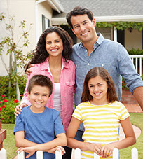 Smiling family in front of their new home.