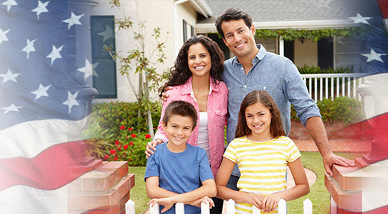 Smiling family standing in fron of their new home, superimposed with an American flag.