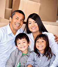 Happy family in front of moving boxes.